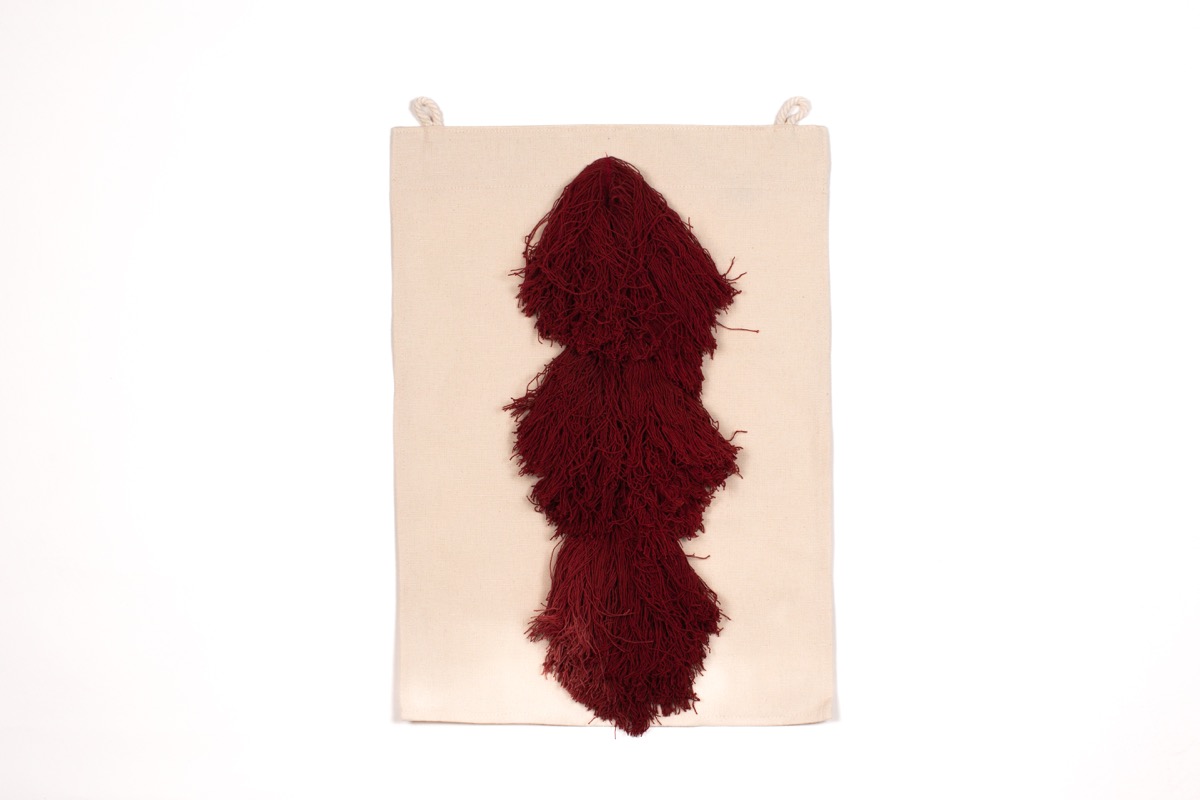 Cojín decorativo de Teixits Vicens con tejido mallorquín en tonos naturales y flecos a juego